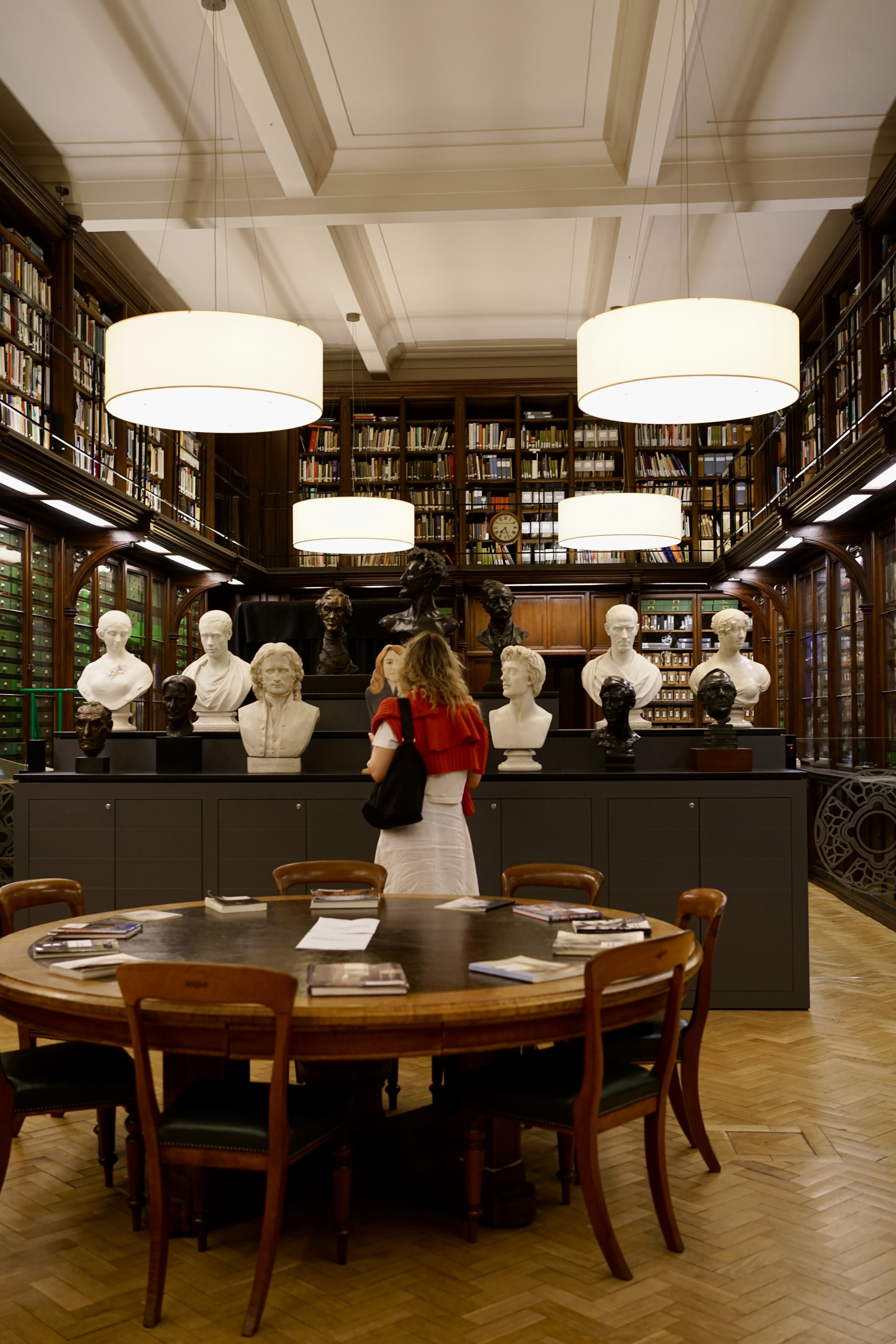 A woman looks at the art in a library within the National Galleries of Scotland