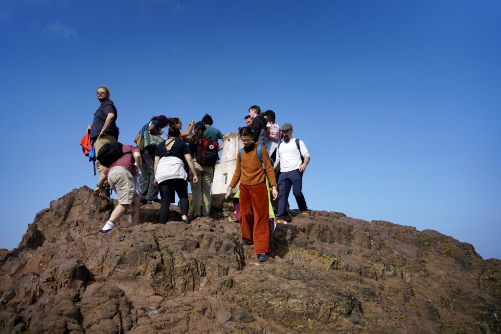 People gathered on the peak of Arthur's Seat hike