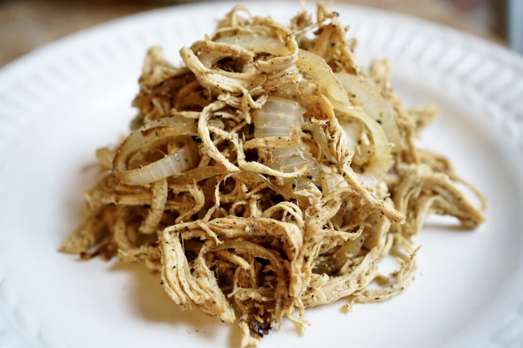 Shredded chicken with onions on a plate