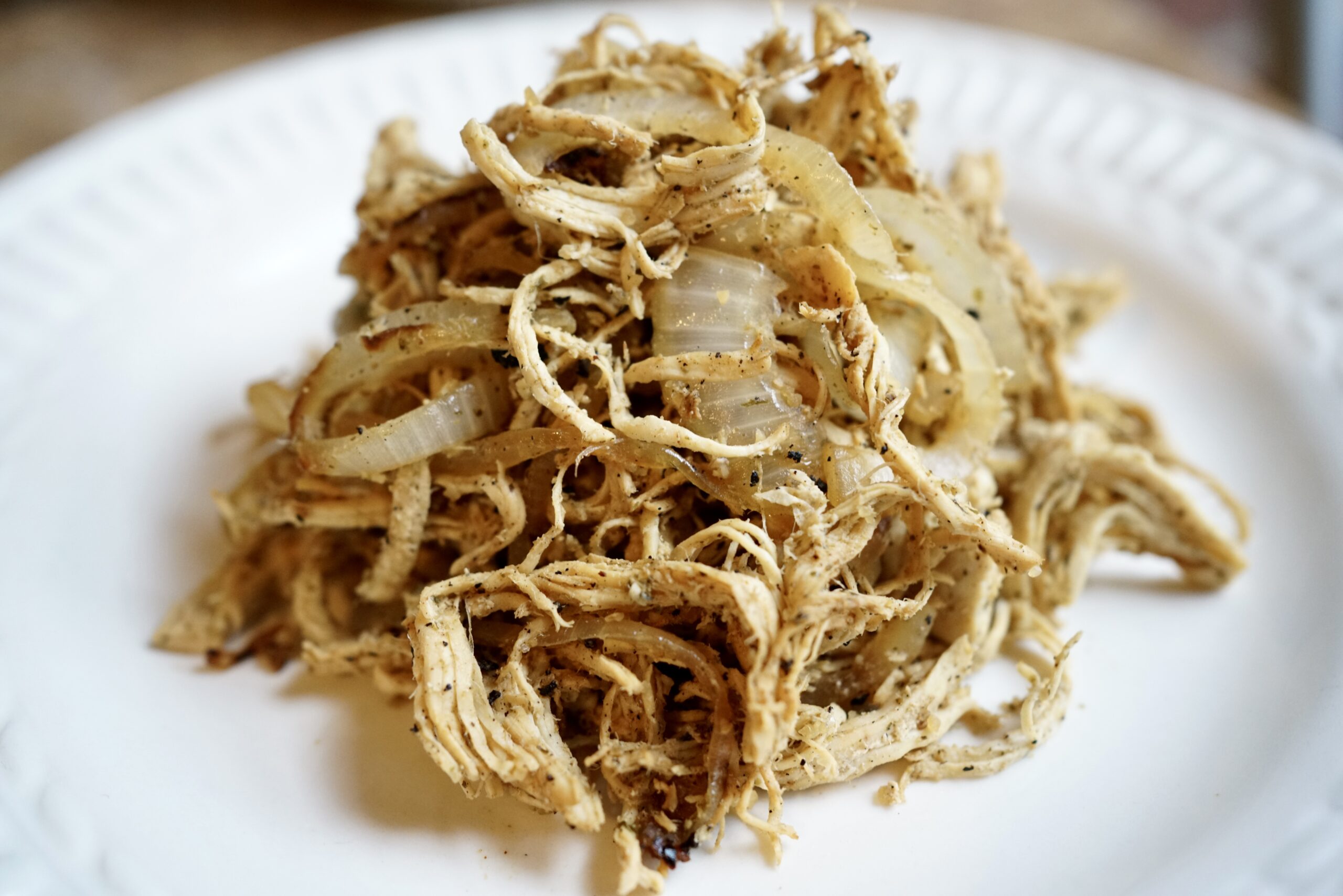 Shredded chicken with onions on a plate