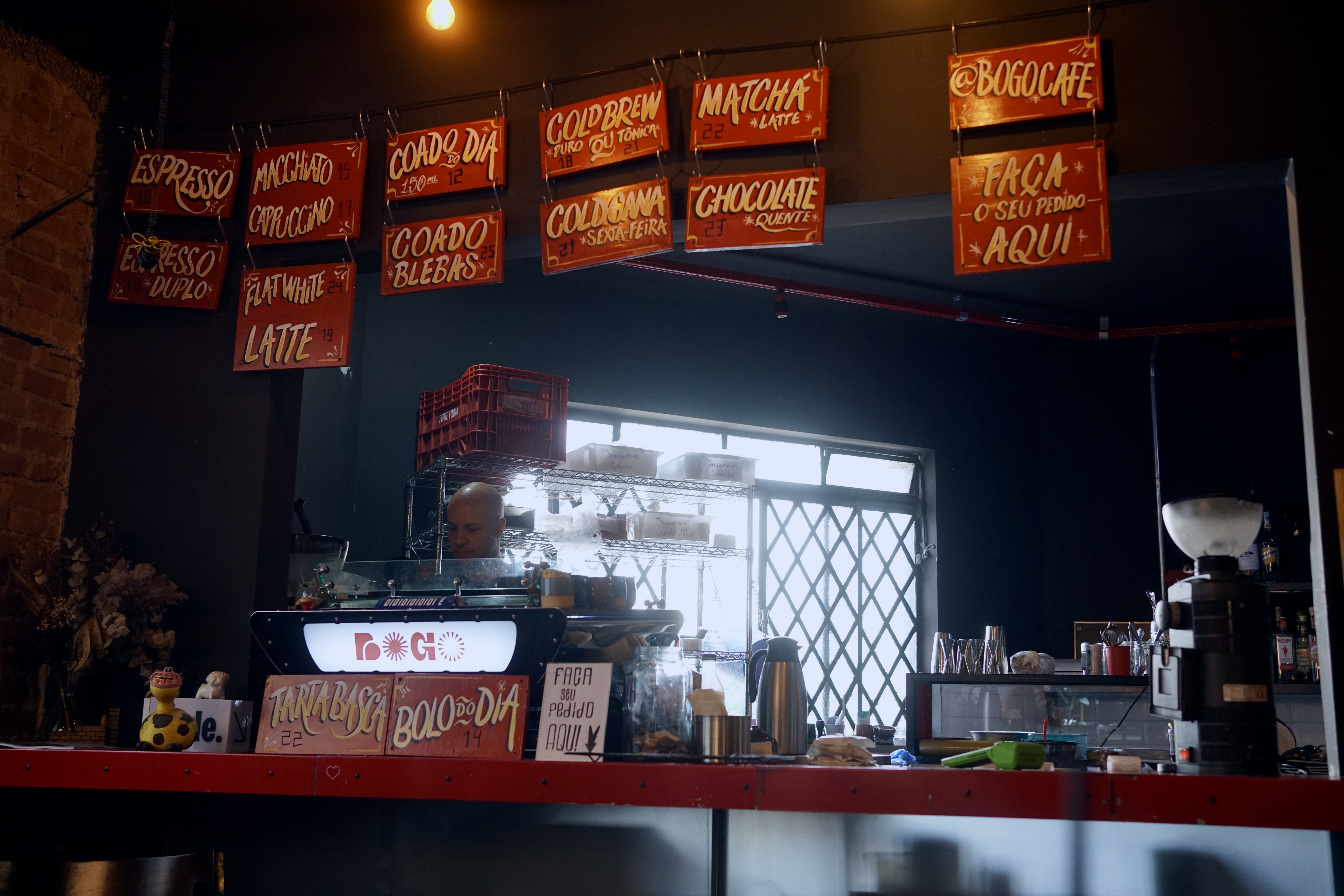The counter at a cafe in São Paulo with menu signs in Portuguese