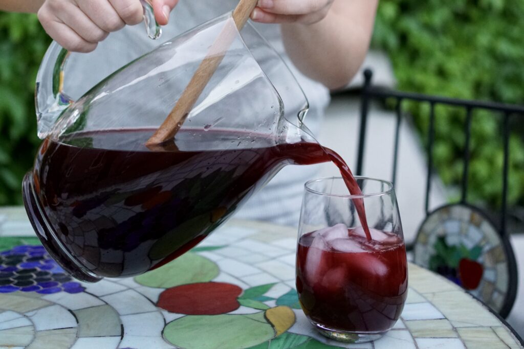 Sangria being poured from a pitcher into a glass