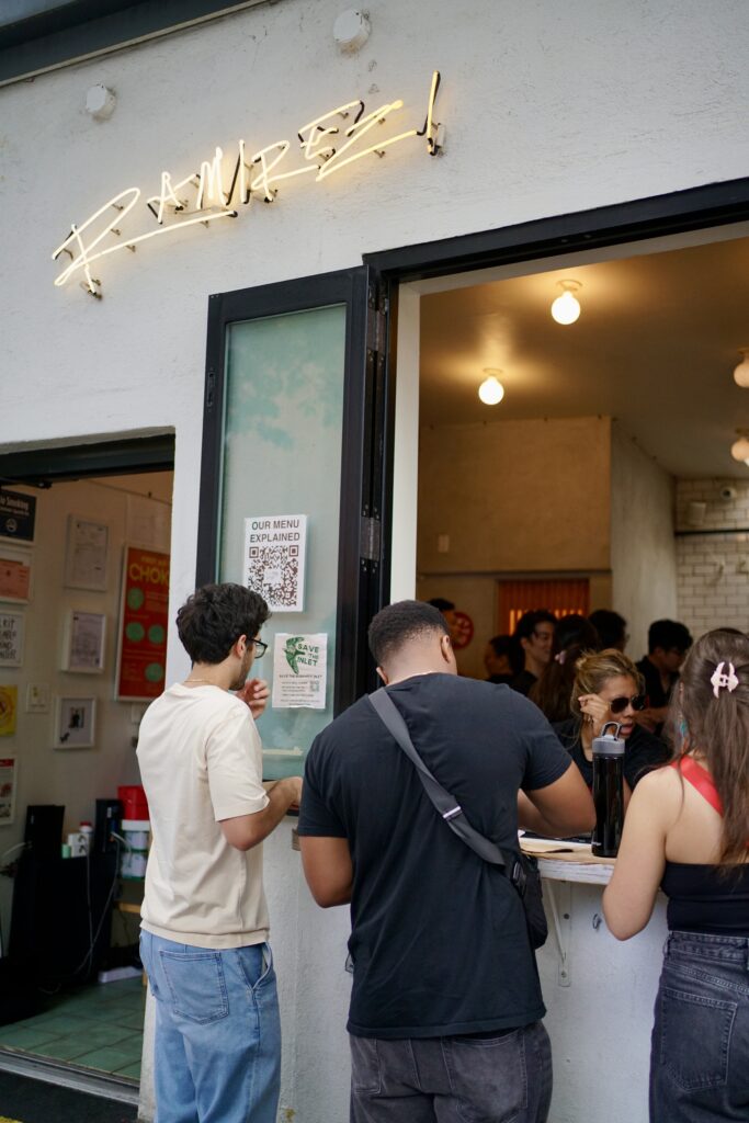 Two men eat at the outdoor counter of Taqueria Ramirez
