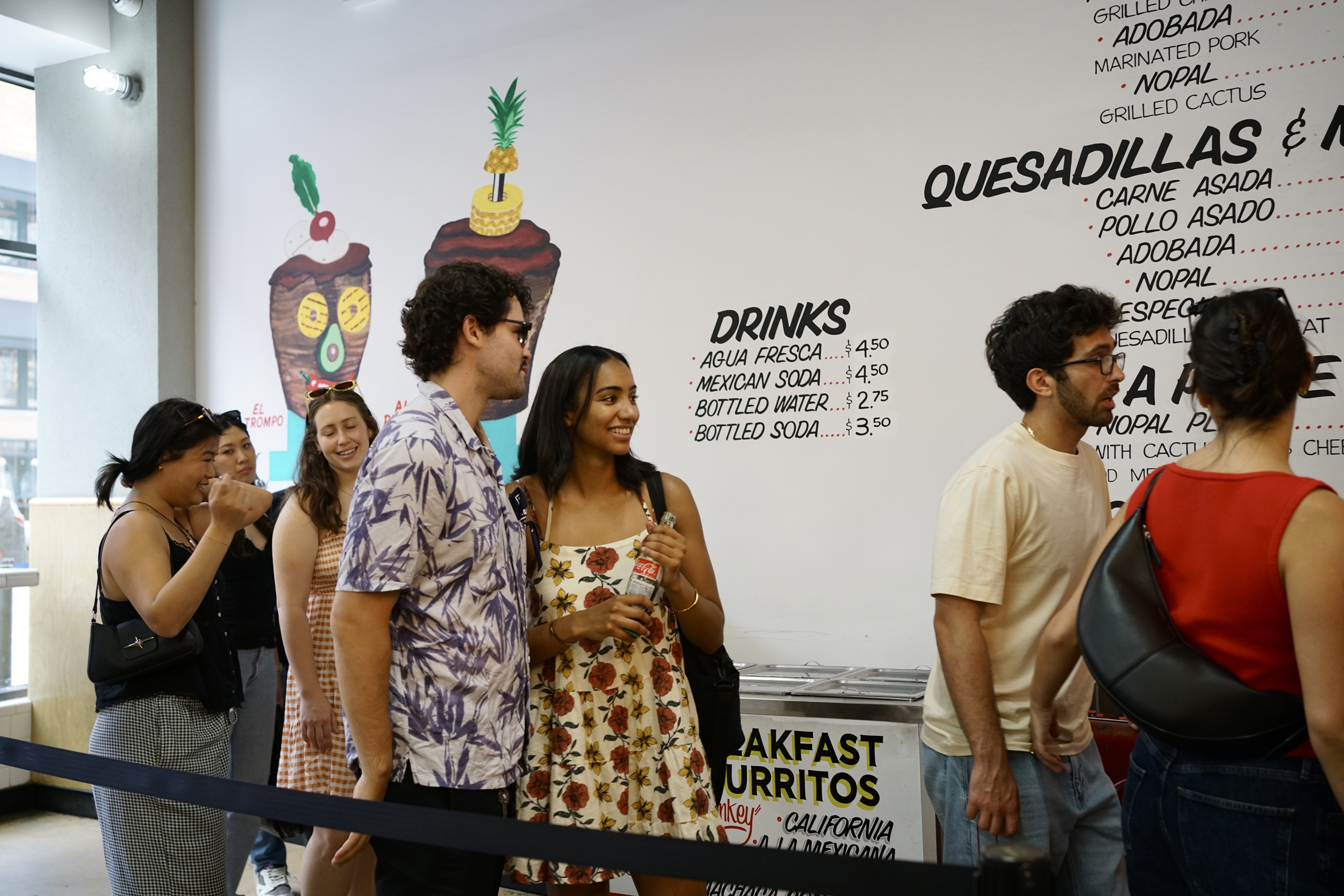 Friends wait in line at Los Tacos No. 1