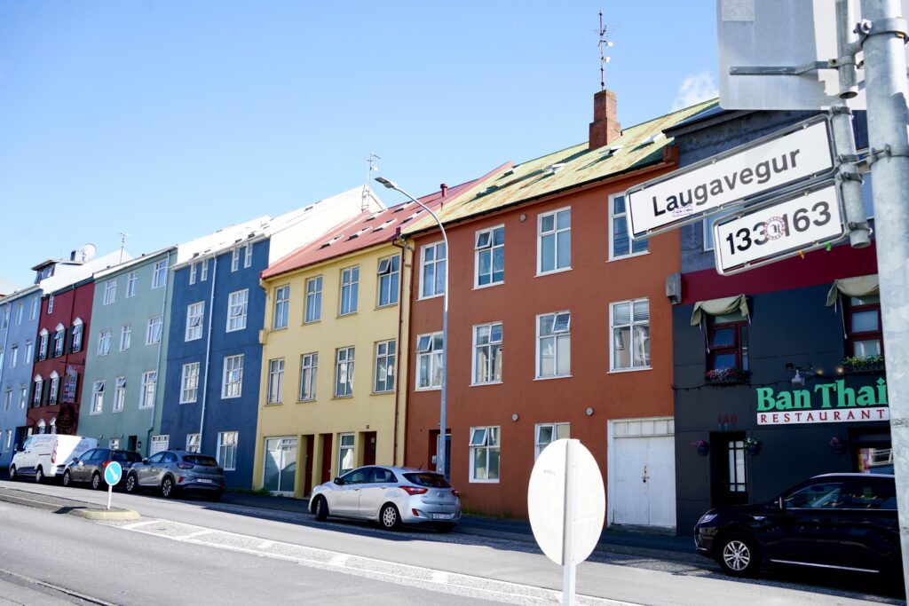A row of colorful houses with a street sign