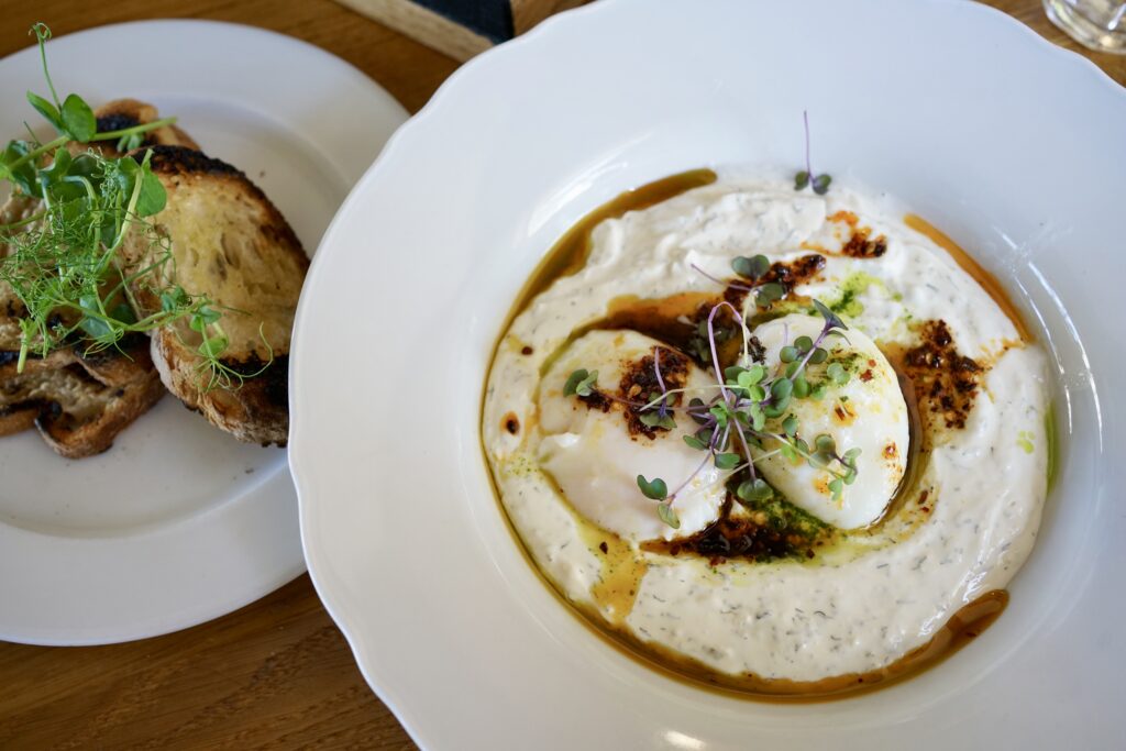 A plate of Turkish eggs and another plate of toast