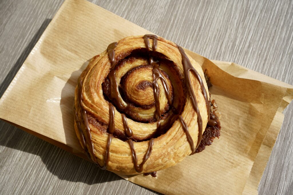 A cinnamon roll with a chocolate drizzle 