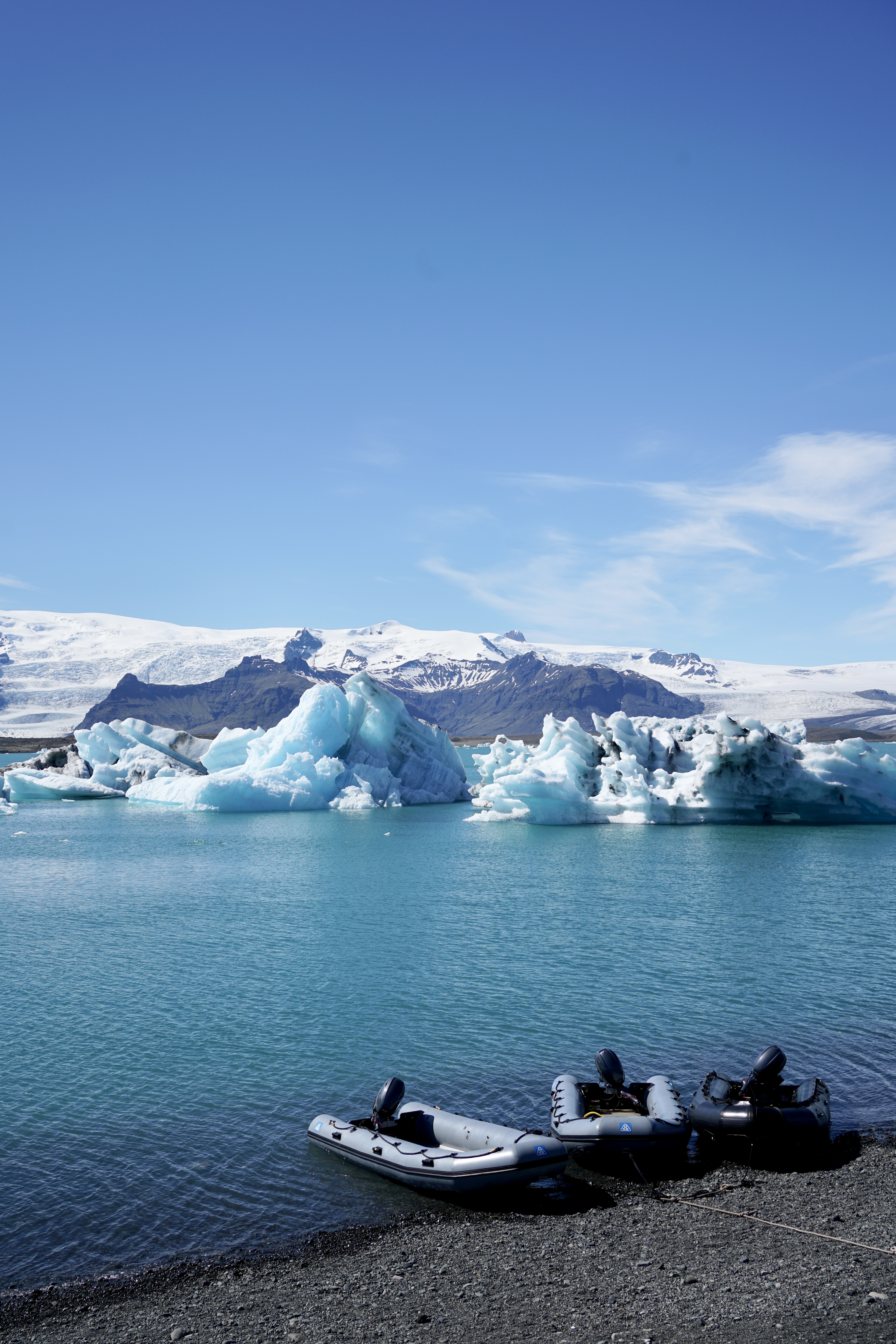Three boats on the edge of a glacier lagoon