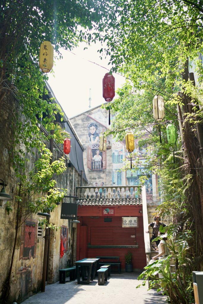 A alleyway in Chinatown with murals and foliage