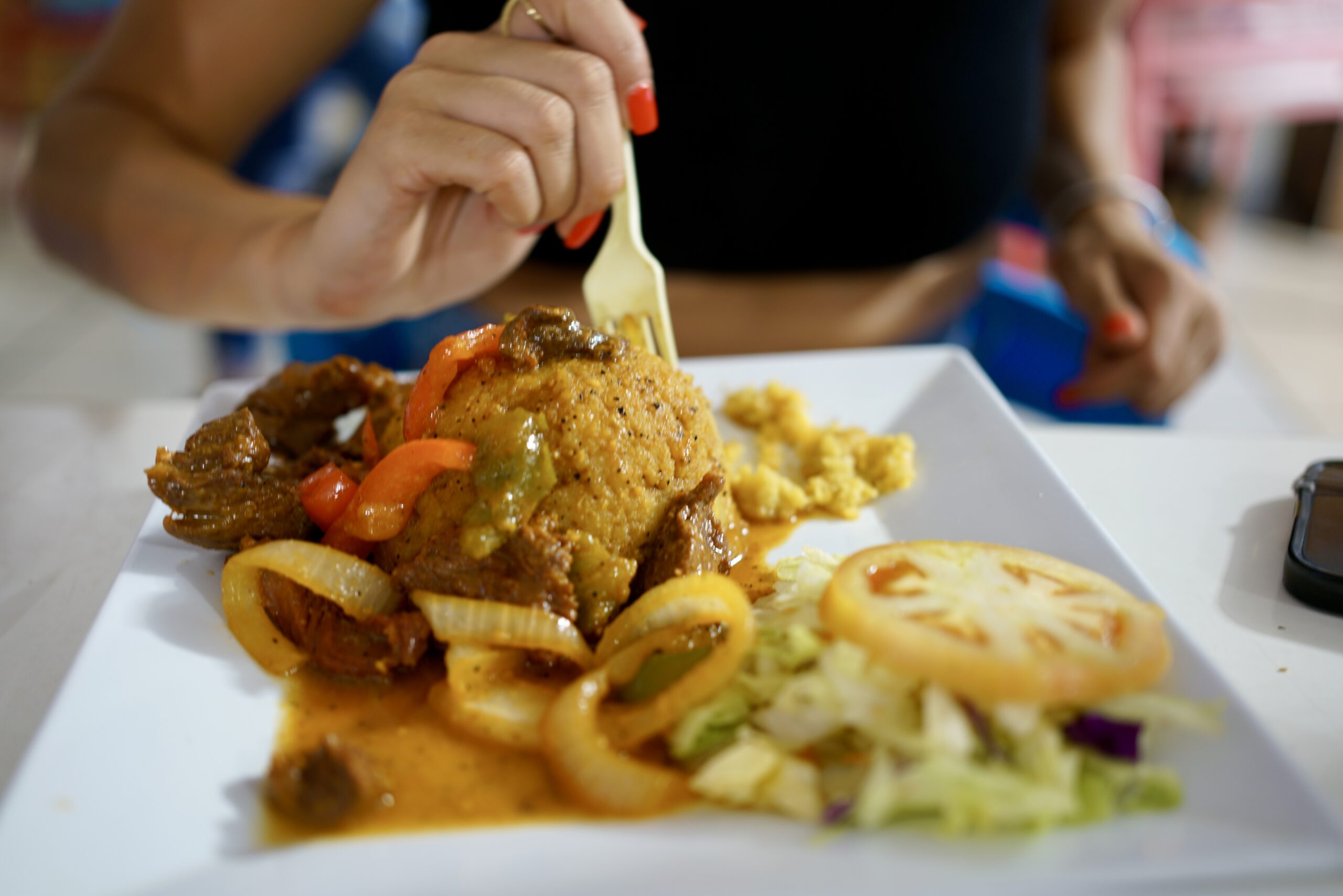 a fork diving into a plate of mofongo with churrasco