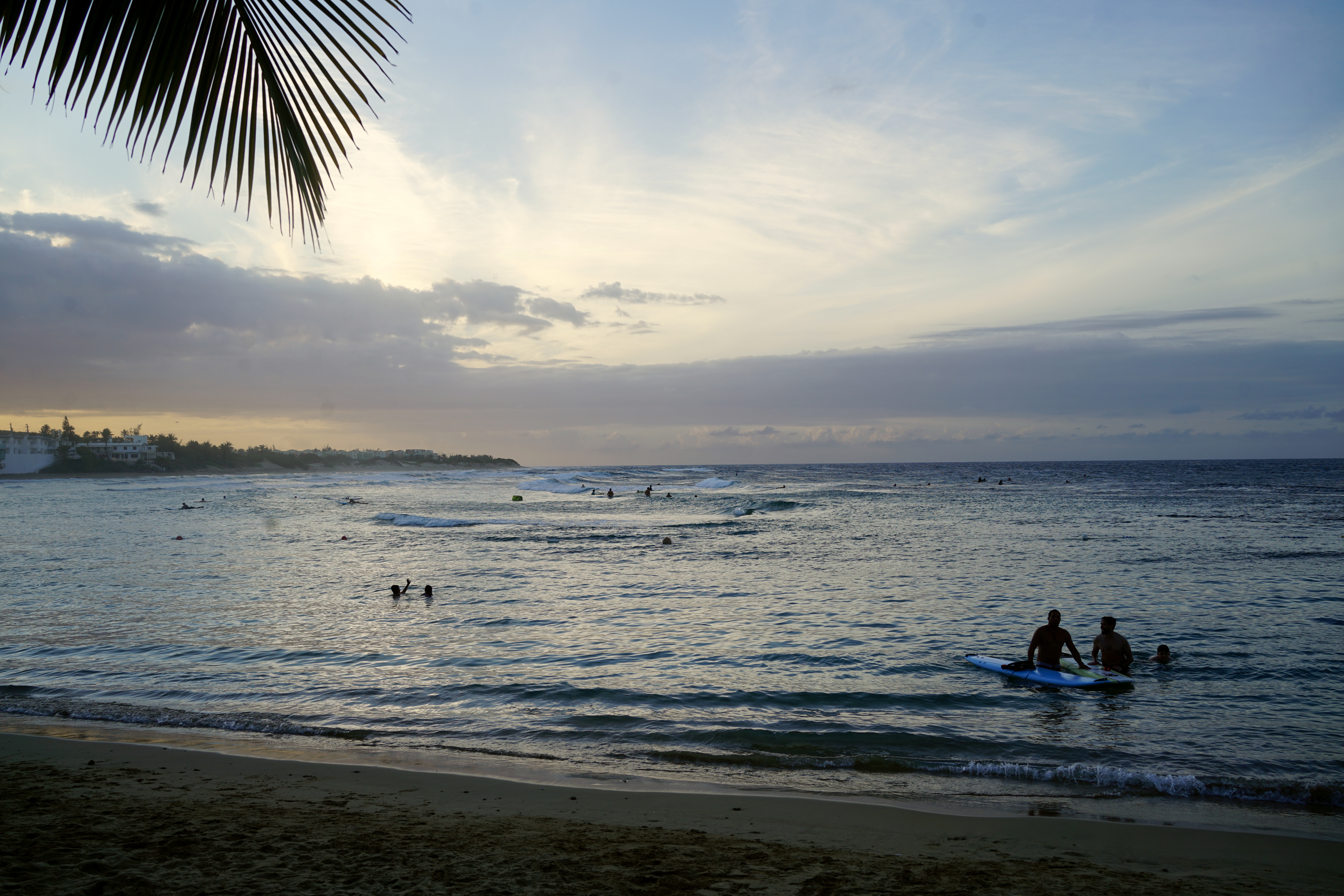 Two surfers in the ocean at sunset
