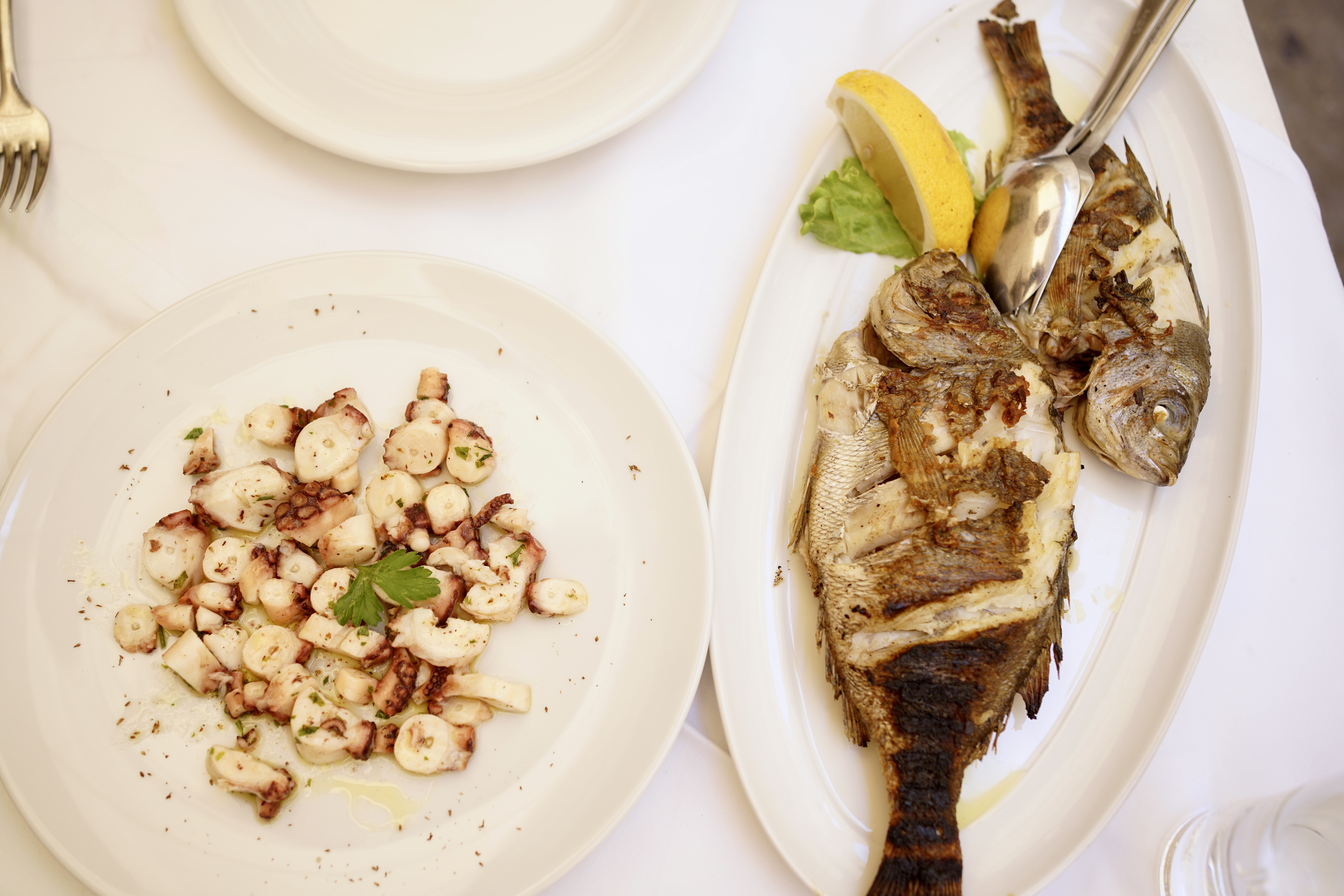 octopus and fish on plates at a restaurant