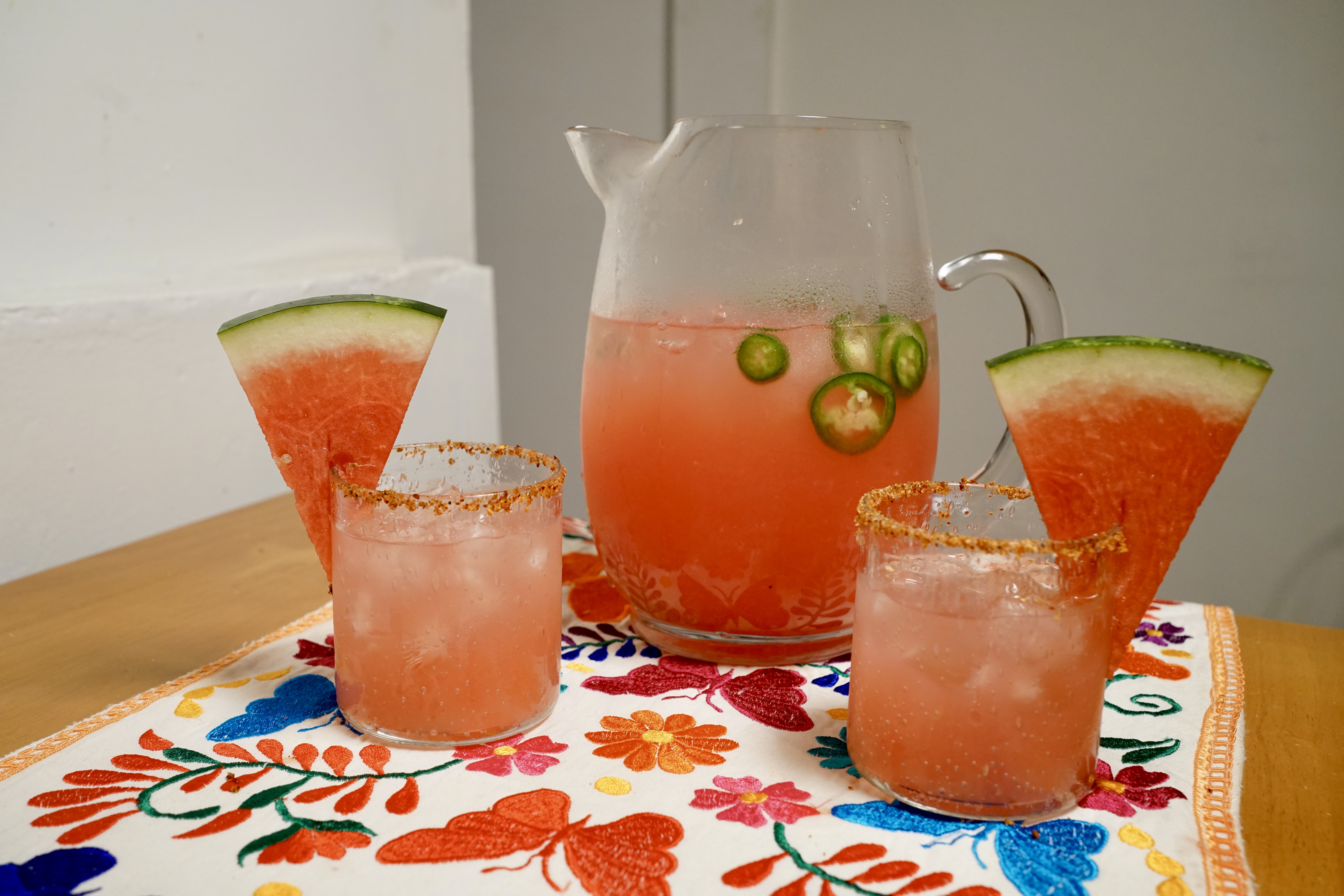A pitcher of spicy watermelon margarita with two glasses